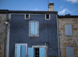 Maison de village bleue marine avec des volets bleus clairs