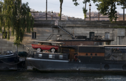 Péniche à quai sur la Seine, transportant une ancienne voiture décapotable rouge